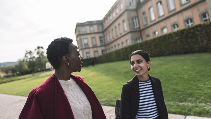 Zwei Personen spazieren und unterhalten sich vor einem historischen Gebäude mit gepflegtem Rasen im Hintergrund., © Stuttgart-Marketing GmbH, wpsteinheisser Zwei Personen spazieren und unterhalten sich vor einem historischen Gebäude mit gepflegtem Rasen im Hintergrund., © Stuttgart-Marketing GmbH, wpsteinheisser