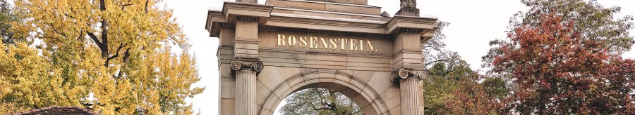 Historic gate with 'Rosenstein' lettering, flanked by buildings. Autumnal trees in the background, two people walking., © TMBW, Christoph Düpper Historic gate with 'Rosenstein' lettering, flanked by buildings. Autumnal trees in the background, two people walking., © TMBW, Christoph Düpper