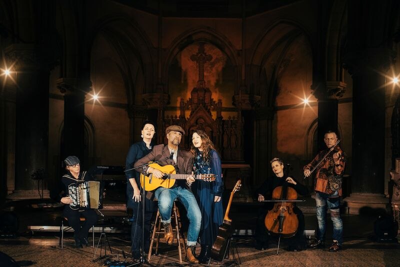 Music group in a church, man with guitar in the middle, surrounded by singers and instrumentalists. Atmospheric lighting., © Live Concept Entertainment GmbH Music group in a church, man with guitar in the middle, surrounded by singers and instrumentalists. Atmospheric lighting., © Live Concept Entertainment GmbH