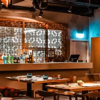 Stilvolles Restaurant mit Holztischen, dekorativen Gittern und einer Bar. An der Wand h&auml;ngen gerahmte Bilder, die Atmosph&auml;re ist warm und einladend., &copy; Breitengrad17 Stuttgart