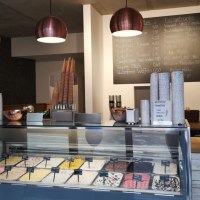 Ice cream parlor with ice cream counter, various types of ice cream, menu board and modern lighting. 'Naturally' lettering on the wall., &copy; Joannis Nakos