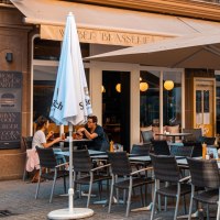Ein Café mit Terrasse, Tischen und Stühlen, Sonnenschirmen und Gästen. Ein Schild wirbt für Frühstücksangebote., © Stuttgart Marketing GmbH, Sarah Schmid Ein Café mit Terrasse, Tischen und Stühlen, Sonnenschirmen und Gästen. Ein Schild wirbt für Frühstücksangebote., © Stuttgart Marketing GmbH, Sarah Schmid