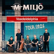 Band Milj&ouml; vor einer blau-wei&szlig;en Kachelwand mit 'Veedeldelphia Tour 2026'-Schriftzug., &copy; links im Bild