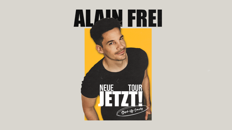 Plakat von Alain Frei mit gelbem Hintergrund, das seine neue Tour "Jetzt!" ank&uuml;ndigt. Er tr&auml;gt ein schwarzes T-Shirt und l&auml;chelt in die Kamera., &copy; links im Bild