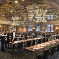 Eleganter Konferenzsaal im Maritim Hotel Stuttgart mit gedeckten Tischen, Kronleuchtern und Personal in Vorbereitung., &copy; Maritim Hotels