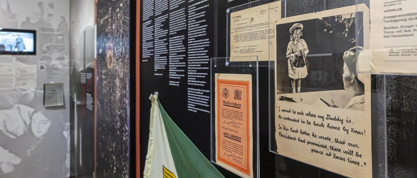 Ausstellungsraum im Polizeimuseum Stuttgart mit historischen Dokumenten, Fotos und Texttafeln an der Wand. Ein Bildschirm zeigt ein Video., &copy; Stuttgart-Marketing GmbH, Sarah Schmid