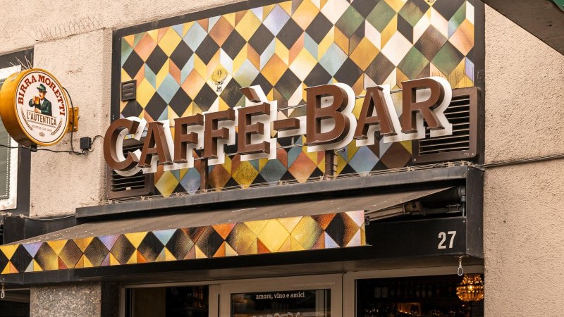 Fassade einer Caffè-Bar mit buntem Rautenmuster und einem Birra Moretti Schild an der Wand., © Stuttgart-Marketing GmbH, Sarah Schmid Fassade einer Caffè-Bar mit buntem Rautenmuster und einem Birra Moretti Schild an der Wand., © Stuttgart-Marketing GmbH, Sarah Schmid