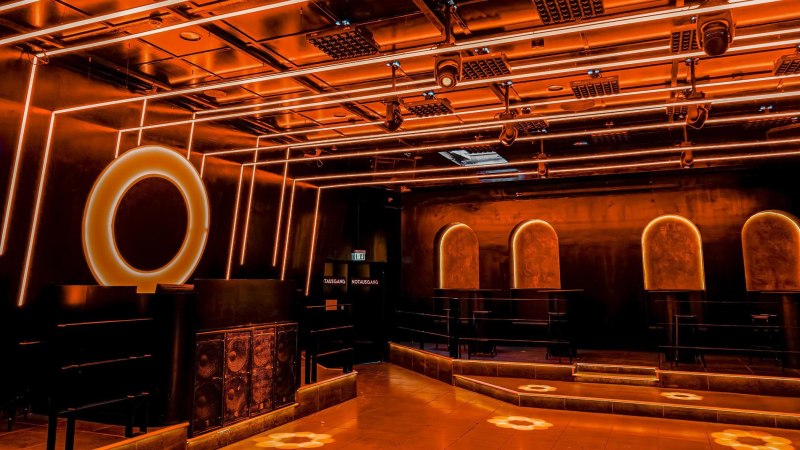 Ein moderner Clubraum mit orangefarbener Beleuchtung, geometrischen Formen und stilvollen Designelementen. Der Raum wirkt futuristisch und einladend., © Wonders, Stuttgart