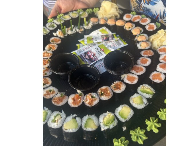 A large plate with various sushi rolls, soy sauce in small bowls and wasabi. Hands and a colorful shirt can be seen in the background., © Cool-Tours StattReisen A large plate with various sushi rolls, soy sauce in small bowls and wasabi. Hands and a colorful shirt can be seen in the background., © Cool-Tours StattReisen