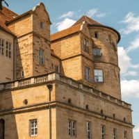 An old castle with striking towers and many windows, surrounded by a blue sky and a few clouds., © Stuttgart-Marketing GmbH, Sarah Schmid