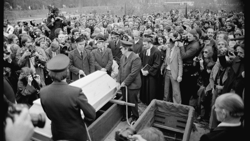 Eine gro&szlig;e Menschenmenge und Fotografen umgeben einen Sarg bei einer Beerdigung auf einem Friedhof., &copy; Stadtarchiv Stuttgart, Foto: Uli Kraufmann, 1069_FN274_20248_009