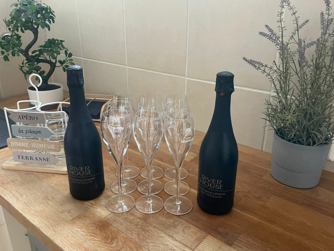 Two champagne bottles and eight glasses stand on a wooden table. Plants and decorative elements can be seen in the background., © Cool-Tours StattReisen Two champagne bottles and eight glasses stand on a wooden table. Plants and decorative elements can be seen in the background., © Cool-Tours StattReisen