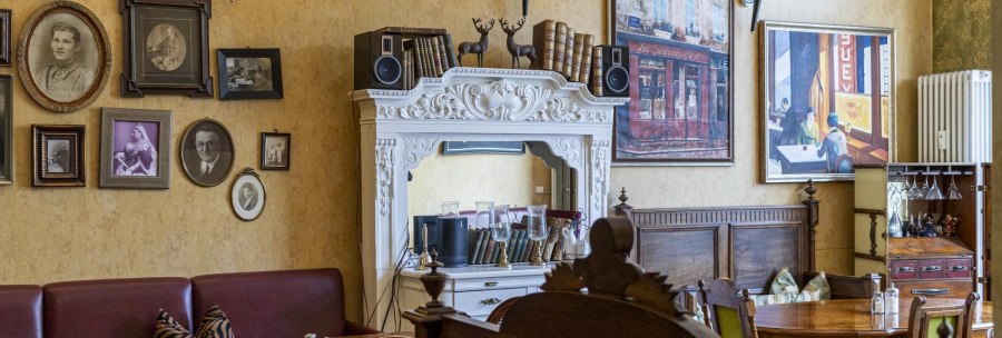 A cozy caf&eacute; with antique furniture, framed pictures and decorative elements on the walls., &copy; SMG, Sarah Schmid