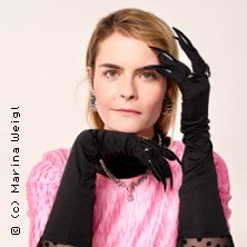 Person mit langen schwarzen Handschuhen und Krallen posiert vor neutralem Hintergrund, trägt ein pinkes Oberteil., © links im Bild Person mit langen schwarzen Handschuhen und Krallen posiert vor neutralem Hintergrund, trägt ein pinkes Oberteil., © links im Bild