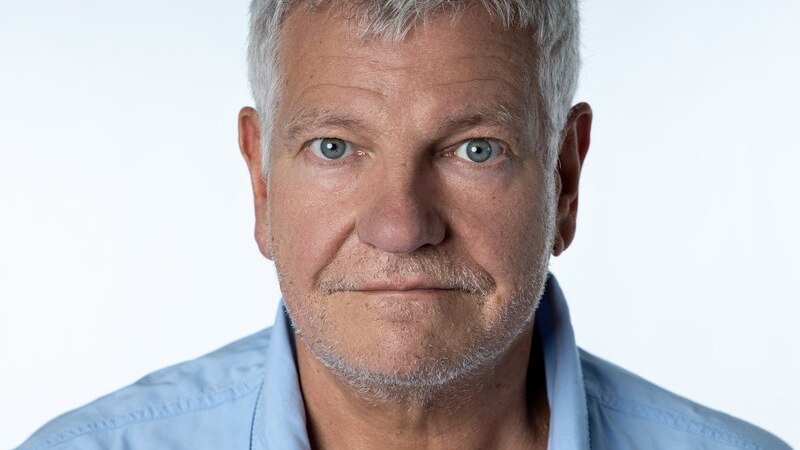 Ein &auml;lterer Mann mit grauen Haaren und Bart tr&auml;gt ein blaues Hemd. Er blickt direkt in die Kamera, der Hintergrund ist hell., &copy; Renitenztheater Stuttgart e.V.