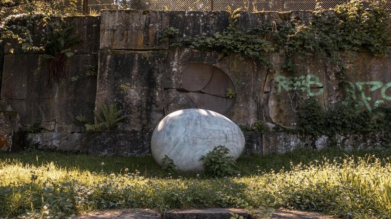 Eine alte Steinmauer mit Graffiti und einer großen Kugel im Vordergrund, umgeben von Gras und Pflanzen im Wartenbergpark., © Stuttgart Marketing GmbH, Sarah Schmid Eine alte Steinmauer mit Graffiti und einer großen Kugel im Vordergrund, umgeben von Gras und Pflanzen im Wartenbergpark., © Stuttgart Marketing GmbH, Sarah Schmid