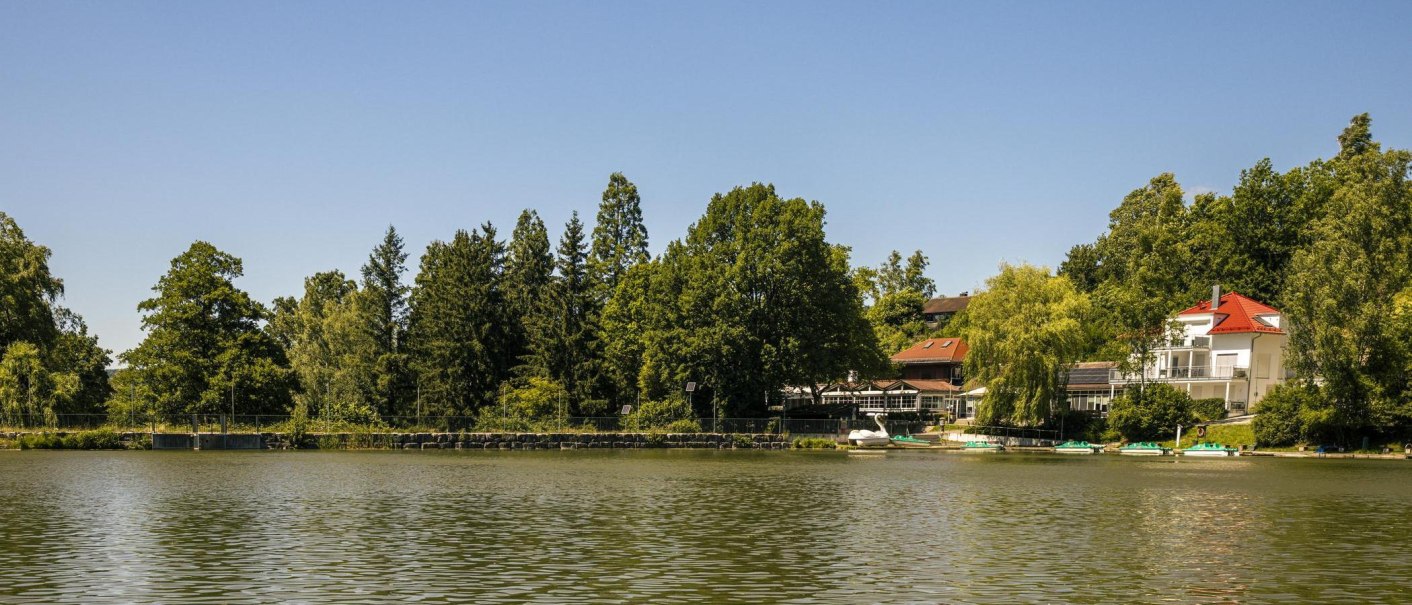 The Waldsee in Fornsbach, with the surrounding trees and buildings along the shore, under a clear sky., © SMG Stuttgart Marketing GmbH - Sarah Schmid The Waldsee in Fornsbach, with the surrounding trees and buildings along the shore, under a clear sky., © SMG Stuttgart Marketing GmbH - Sarah Schmid