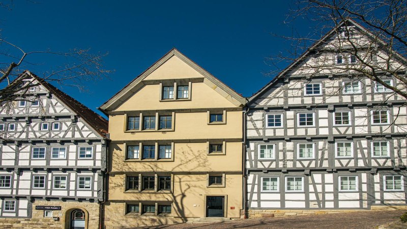 Three half-timbered houses on the market square in Böblingen, surrounded by bare trees and a bright blue sky., © SMG Stuttgart Marketing GmbH - Sarah Schmid Three half-timbered houses on the market square in Böblingen, surrounded by bare trees and a bright blue sky., © SMG Stuttgart Marketing GmbH - Sarah Schmid