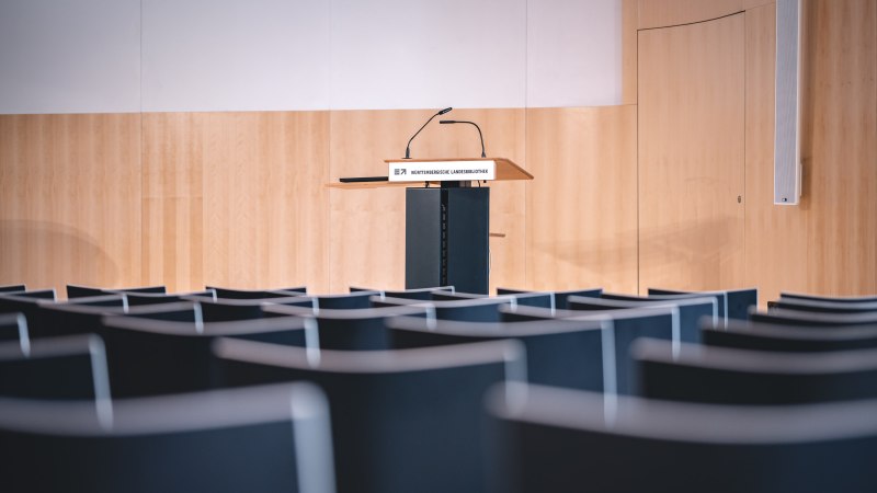 Leerer Vortragssaal mit einem Rednerpult der Württembergischen Landesbibliothek, umgeben von leeren Stuhlreihen., © Marcel Katz Leerer Vortragssaal mit einem Rednerpult der Württembergischen Landesbibliothek, umgeben von leeren Stuhlreihen., © Marcel Katz