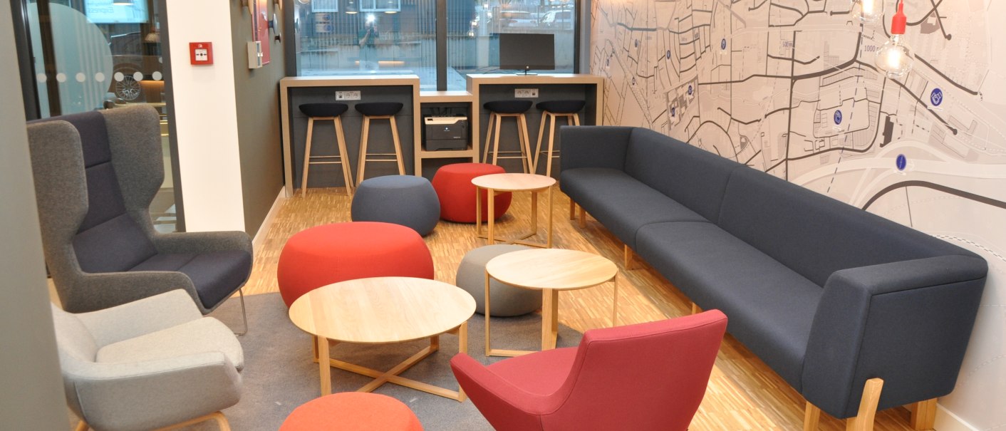 Modern lobby at the Holiday Inn Express Sindelfingen with colorful armchairs, stools and tables. A large wall map and hanging lamps decorate the room., © tristar GmbH Modern lobby at the Holiday Inn Express Sindelfingen with colorful armchairs, stools and tables. A large wall map and hanging lamps decorate the room., © tristar GmbH