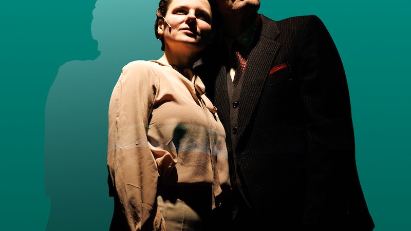 Ein Mann und eine Frau stehen eng beieinander vor einem gr&uuml;nen Hintergrund. Sie schauen nach oben, w&auml;hrend ihre Schatten hinter ihnen sichtbar sind., &copy; Theater der Altstadt