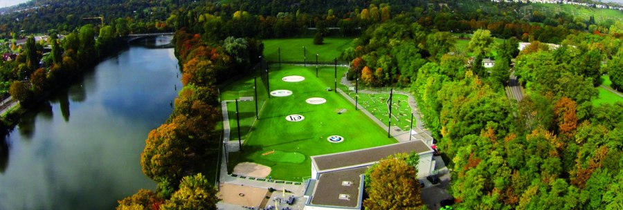Aerial view of a golf course in Stuttgart, surrounded by trees and a river. Hills and buildings can be seen in the background., © Citygolf Stuttgart