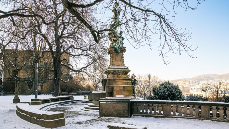 Snow-covered Eugensplatz in Stuttgart with the Galatea Fountain in the foreground. The trees are bare and the city is visible in the background., &copy; Stuttgart-Marketing GmbH, Sarah Schmid
