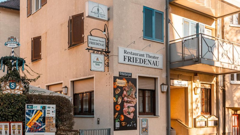 Das Restaurant Theater Friedenau zeigt seine Fassade mit mehreren Schildern und einem Werbeplakat. Ein Biergarten ist ebenfalls sichtbar., &copy; Stuttgart-Marketing GmbH, Sarah Schmid