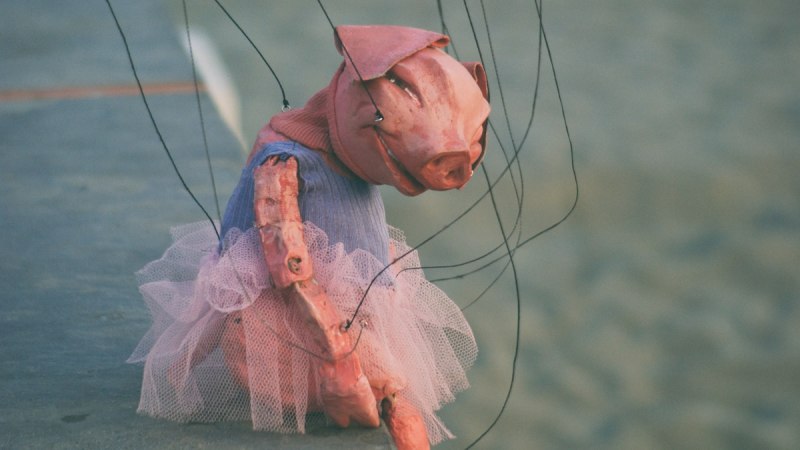 Eine Schweinemarionette in rosa Kleidung und T&uuml;llrock h&auml;ngt an F&auml;den und scheint auf einer B&uuml;hne zu stehen., &copy; Fotocredit Theater La Lune Stuttgart