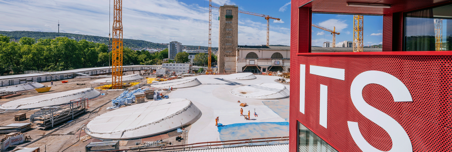 View of a construction site with several cranes and a red building with the inscription 'ITS' in the foreground., &copy; Thomas Niederm&uuml;ller