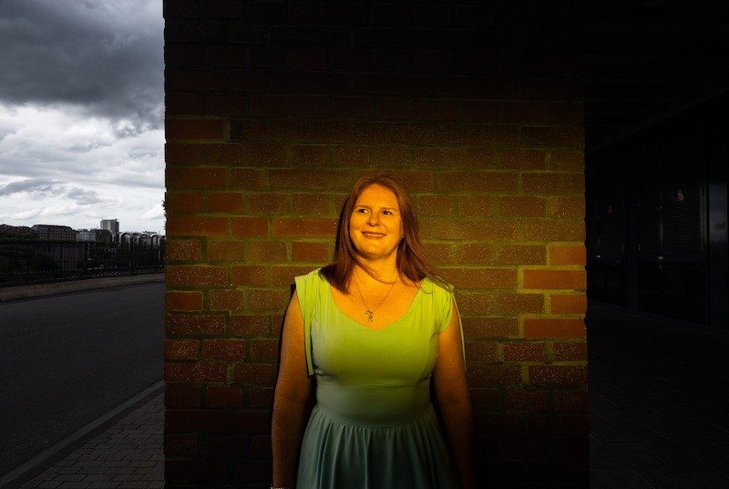 Frau in grünem Kleid vor Backsteinwand, gelbes Licht auf sie gerichtet, dunkler Himmel im Hintergrund., © Rosenau Kultur e.V. Frau in grünem Kleid vor Backsteinwand, gelbes Licht auf sie gerichtet, dunkler Himmel im Hintergrund., © Rosenau Kultur e.V.