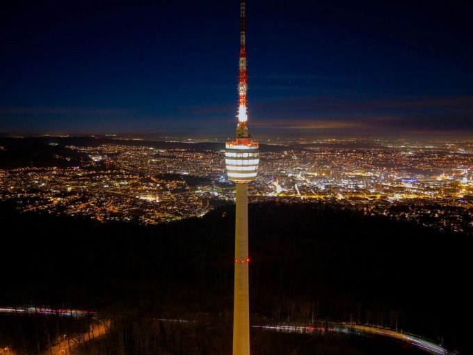 Der Fernsehturm steht beleuchtet in der Nacht, umgeben von der erleuchteten Stadt im Hintergrund. Der Himmel ist dunkelblau., &copy; SWR Media Services GmbH / SWR Fernsehturm Stuttgart