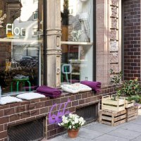 A cozy caf&eacute; with plants and cushions on the windowsill. A sign advertises coffee and cookies. The fa&ccedil;ade is made of brown bricks., &copy; Stuttgart-Marketing GmbH, Sarah Schmid