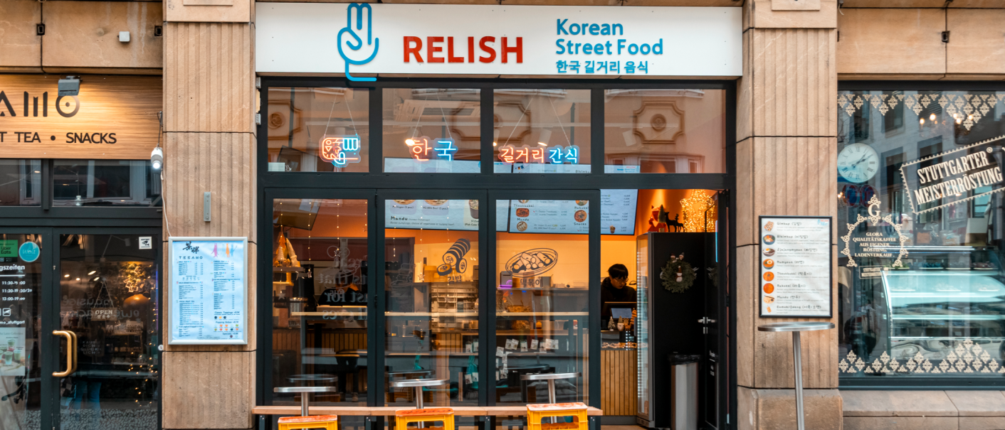 Das Bild zeigt die Fassade des Restaurants 'Relish', das koreanisches Street Food anbietet. Die Glasfront ist mit Neonlichtern dekoriert., &copy; Stuttgart-Marketing GmbH, Sarah Schmid