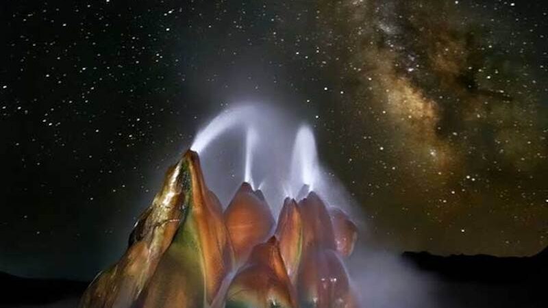 Ein bunter Geysir sprüht Wasser in die Luft, während die Milchstraße am Nachthimmel leuchtet. Die Szenerie wirkt mystisch und beeindruckend., © Theaterhaus Stuttgart e.V. Ein bunter Geysir sprüht Wasser in die Luft, während die Milchstraße am Nachthimmel leuchtet. Die Szenerie wirkt mystisch und beeindruckend., © Theaterhaus Stuttgart e.V.