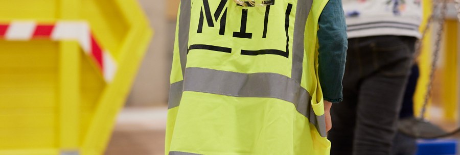 Children at a play construction site in the StadtPalais, wearing construction helmets and high-visibility vests. Colorful play equipment can be seen in the background., &copy; Julia Ochs