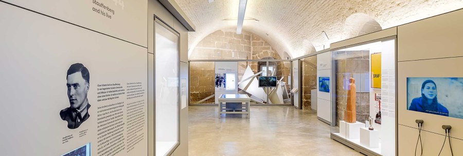Interior view of the Stauffenberg memorial with modern exhibits, information boards and screens in a vaulted room., © Daniel Stauch Photography