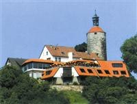 Burghotel mit rotem Dach und Turm, umgeben von grünen Bäumen, unter blauem Himmel., © Burghotel Schöne Aussicht Burghotel mit rotem Dach und Turm, umgeben von grünen Bäumen, unter blauem Himmel., © Burghotel Schöne Aussicht