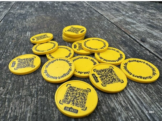 Gelbe Chips mit QR-Codes und der Aufschrift 'stuttgart-tourist.de' liegen auf einem Holztisch verstreut., © Stuttgart Marketing GmbH Gelbe Chips mit QR-Codes und der Aufschrift 'stuttgart-tourist.de' liegen auf einem Holztisch verstreut., © Stuttgart Marketing GmbH