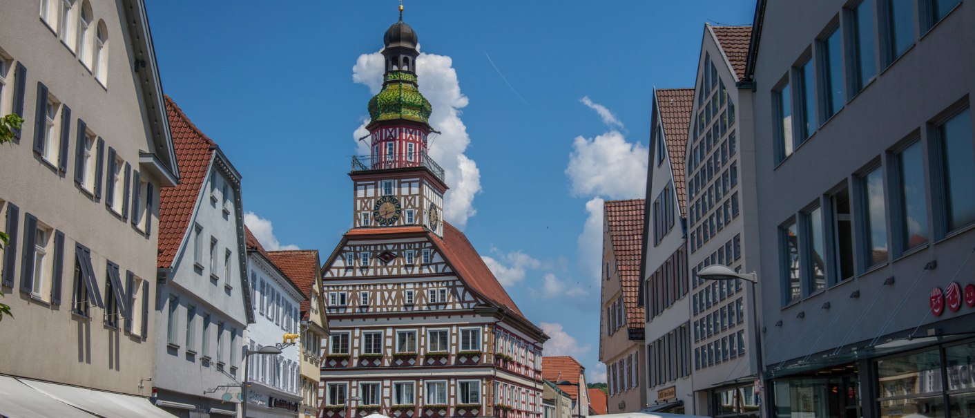 A historic half-timbered town hall in a German city, surrounded by modern buildings. The sky is blue with a few clouds., © Stadt Kirchheim unter Teck A historic half-timbered town hall in a German city, surrounded by modern buildings. The sky is blue with a few clouds., © Stadt Kirchheim unter Teck