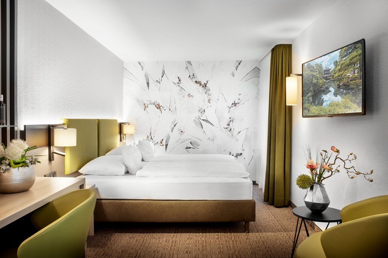 A modern hotel room with a double bed, stylish wall decor, a desk, and a TV. Elegant lighting and decor create a welcoming atmosphere., &copy; TOMAS
