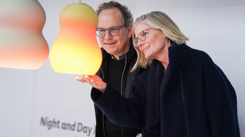 Zwei Personen betrachten bunte, birnenf&ouml;rmige Lampen auf der BLICKFANG Stuttgart. Die Lampen leuchten in sanften Farbverl&auml;ufen., &copy; BLICKFANG GmbH