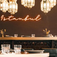 Ein stilvoll eingerichtetes Restaurant mit orientalischen Lampen und einem leuchtenden "Istanbul"-Neonschriftzug an der Wand., © Noa, Stuttgart