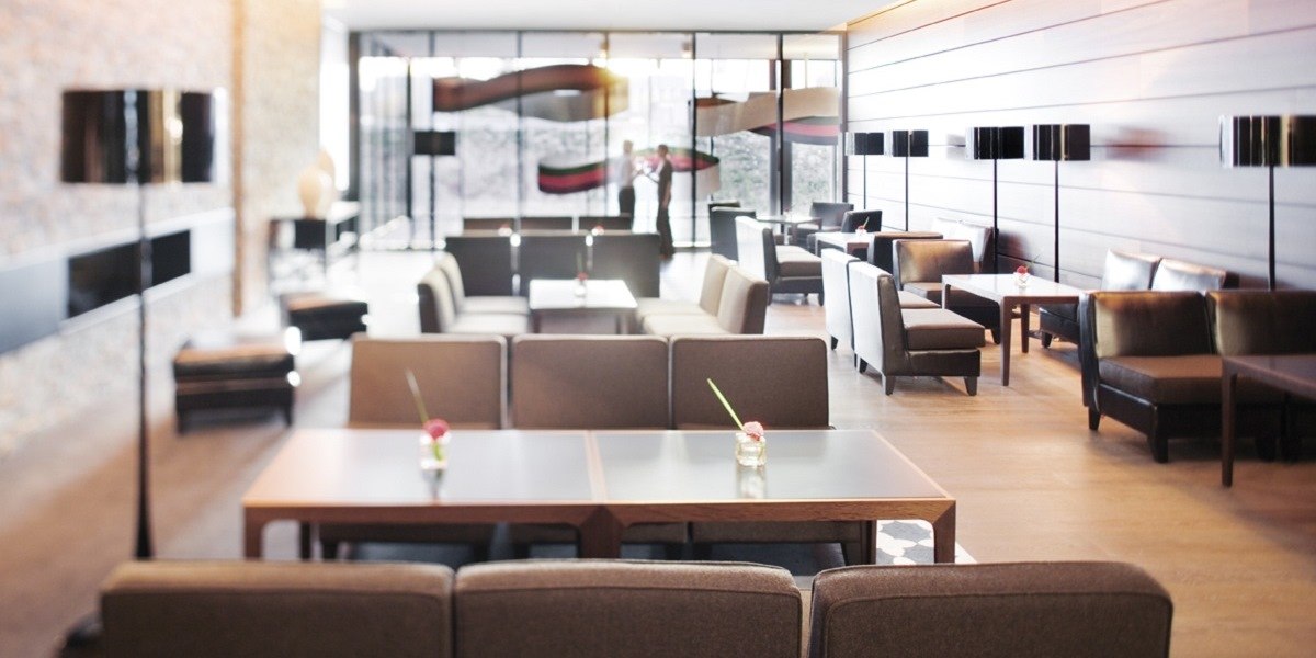 Moderne Lounge mit Sofas, Tischen und Blumenvasen. Große Fenster im Hintergrund lassen viel Licht herein., © Mövenpick Hotel Stuttgart Airport Moderne Lounge mit Sofas, Tischen und Blumenvasen. Große Fenster im Hintergrund lassen viel Licht herein., © Mövenpick Hotel Stuttgart Airport