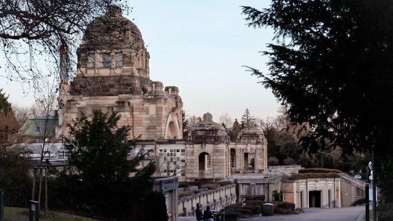 Historisches Krematorium auf dem Pragfriedhof in Stuttgart, umgeben von Bäumen und einem klaren Himmel., © Stuttgart-Marketing GmbH