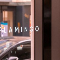 Wei&szlig;er Schriftzug "FLAMINGO" in Gro&szlig;buchstaben auf der verspiegelten Glasfront der Bar, &copy; SMG, Sarah Schmid