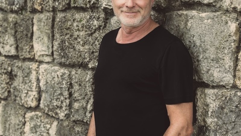 Ein Mann mit Strohhut und schwarzem T-Shirt lehnt lächelnd an einer alten Steinmauer., © Renitenztheater Stuttgart e.V. Ein Mann mit Strohhut und schwarzem T-Shirt lehnt lächelnd an einer alten Steinmauer., © Renitenztheater Stuttgart e.V.