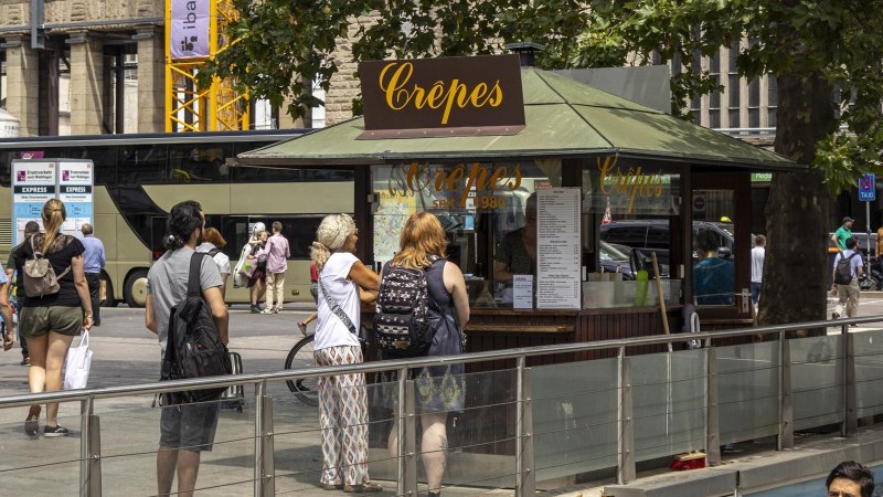 A crêpes stand at Stuttgart Central Station with several people queuing. Bicycles and a bus can be seen in the background., © SMG Stuttgart Marketing GmbH - Sarah Schmid