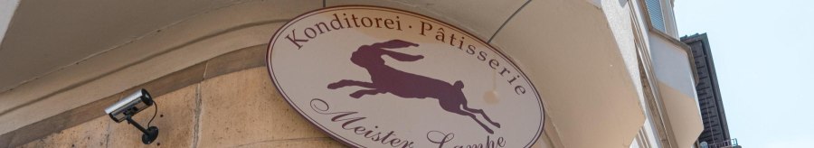 Schild der Konditorei 'Meister Lampe' mit springendem Hasen, an einer Geb&auml;udefassade montiert., &copy; SMG, Sarah Schmid