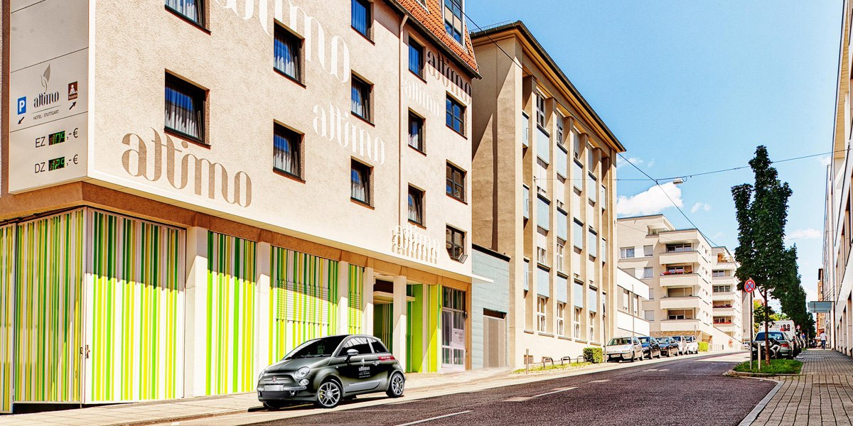 Außenansicht eines Hotels mit dem Namen 'attimo', bunte Fassade, parkendes Auto davor., © attimo Außenansicht eines Hotels mit dem Namen 'attimo', bunte Fassade, parkendes Auto davor., © attimo